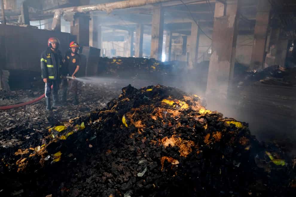 Firefighters work to douse a fire inside a food and beverage factory in Rupganj, outside Dhaka, Bangladesh (Mahmud Hossain Opu/AP)