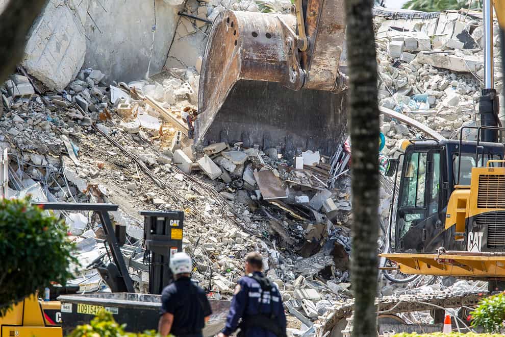 Excavators dig through the rubble of the Champlain Towers (Pedro Portal/AP)