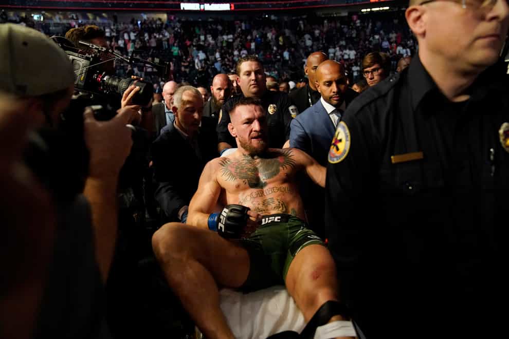 Conor McGregor leaves the arena on a stretcher after suffering a suspected broken leg.