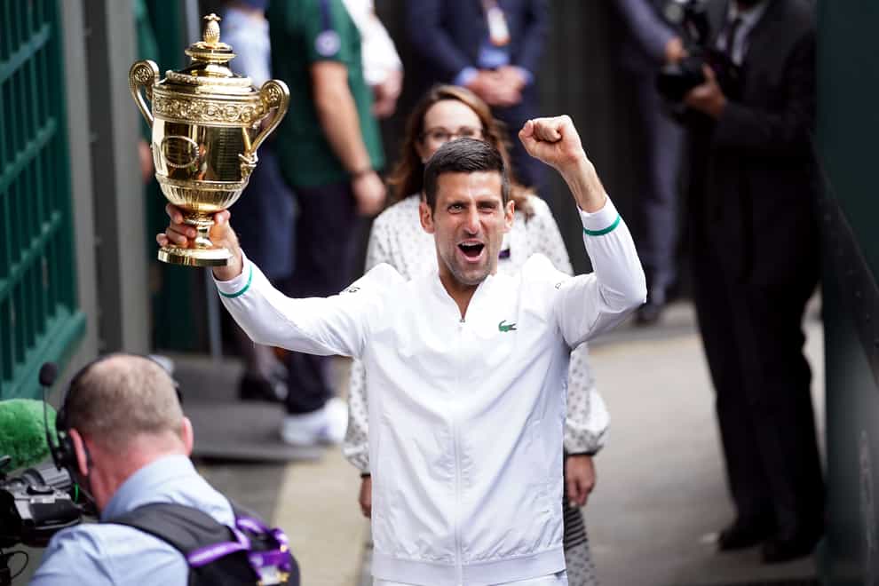 Novak Djokovic leaves Centre Court with the Wimbledon trophy