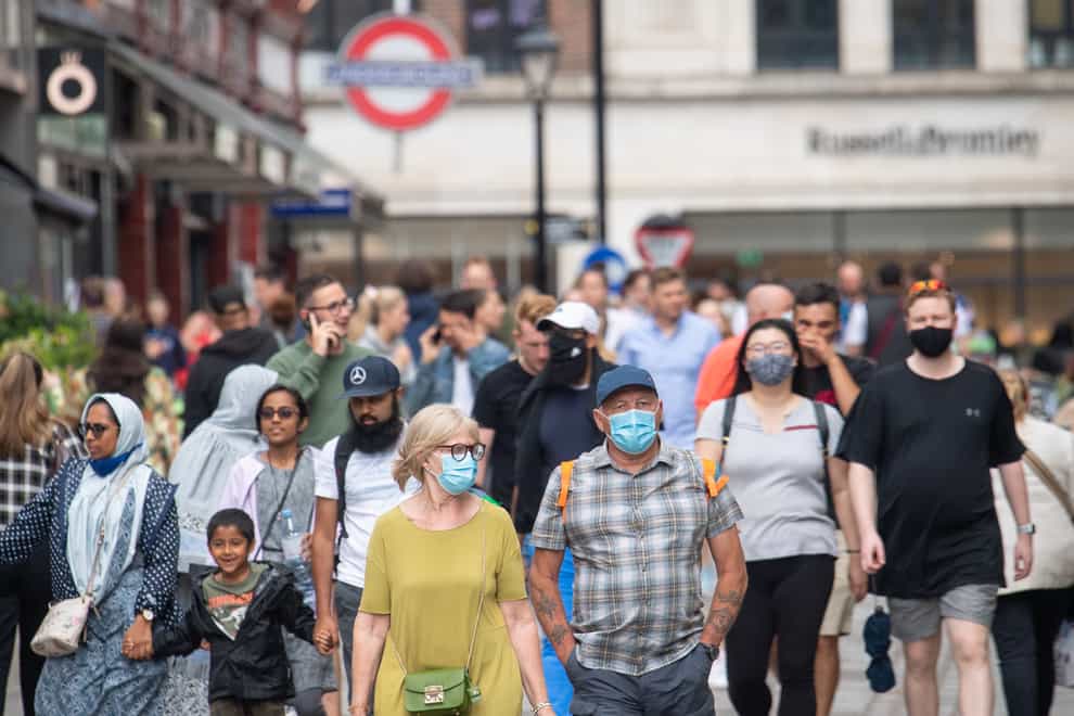 People wearing face masks among crowds of pedestrians in Covent Garden, London