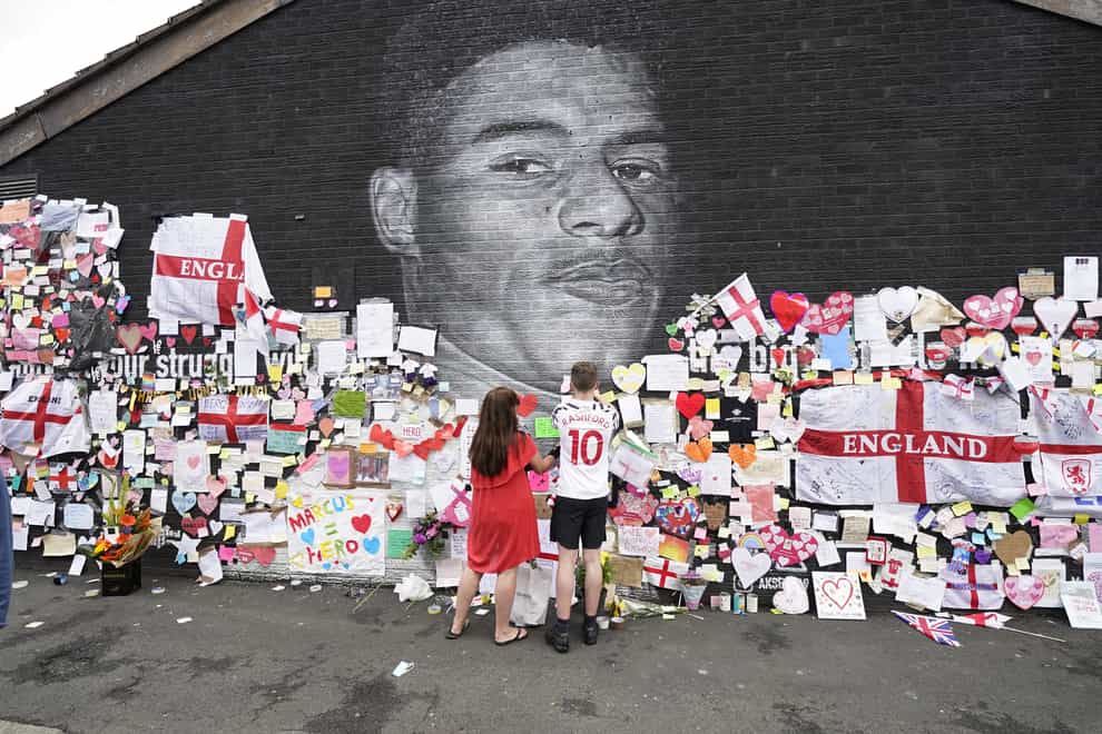 A mural of Marcus Rashford which had been defaced is adorned with messages of support