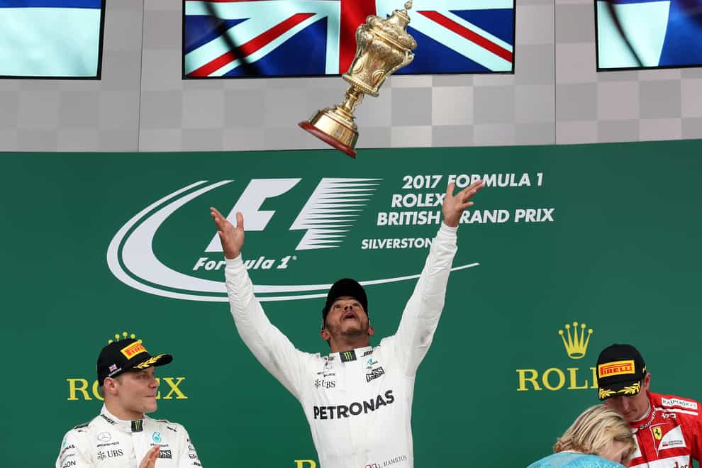 Lewis Hamilton (centre) celebrates his victory on the podium in 2017
