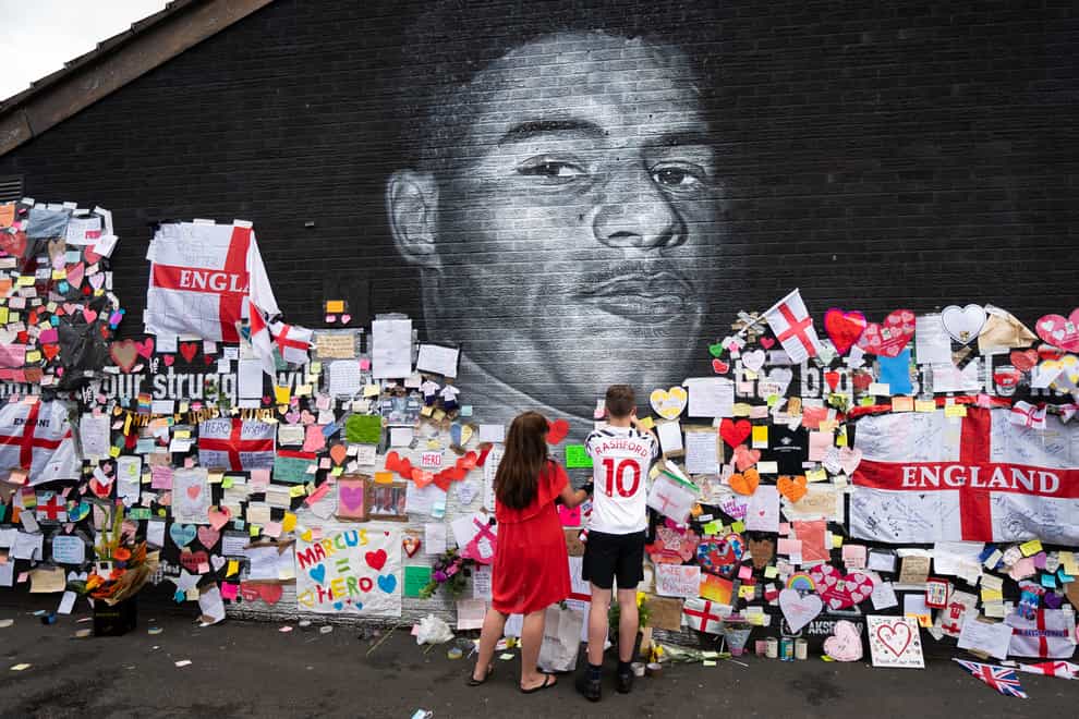 Fans add messages of support to the mural of Marcus Rashford in Manchester