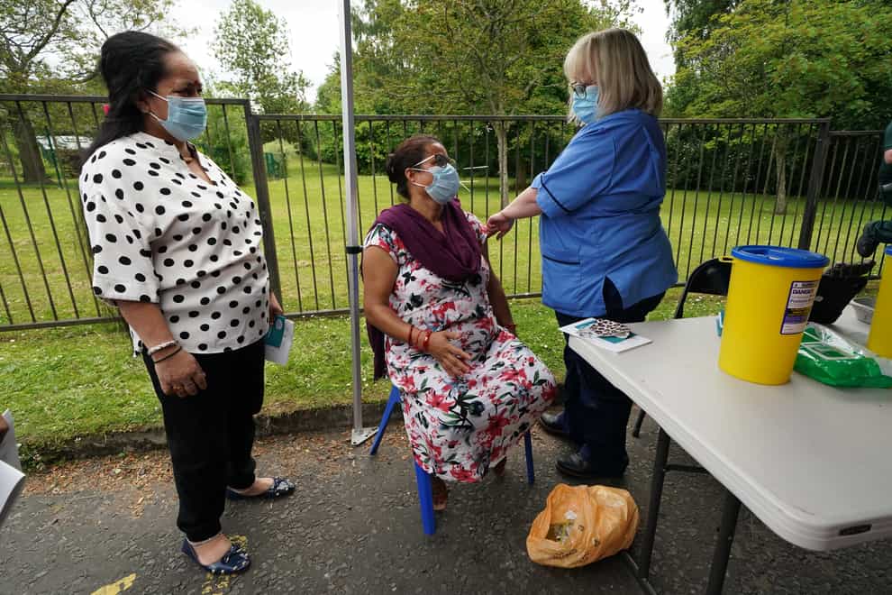 Vaccination nurse Lorraine Mooney gives a vaccination to members of the public outside a bus in the car park of Crieff community hospital in Perth and Kinross