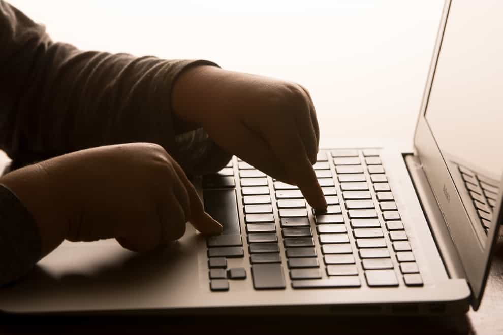 A child’s hands on the keys of a laptop keyboard