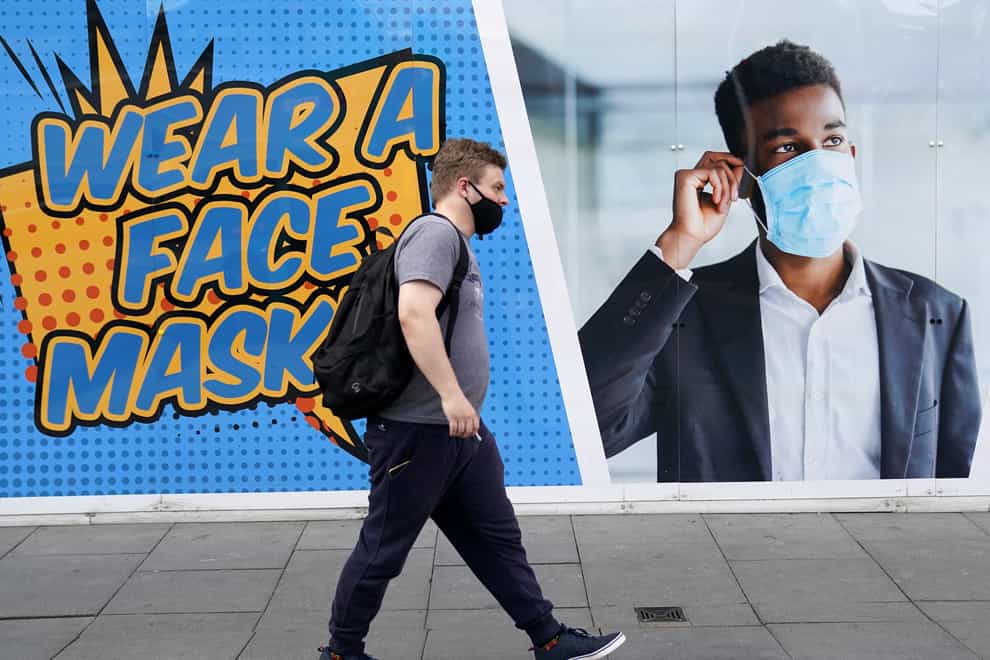 A member of the public walks past a notice in Nottingham encouraging the wearing of mask for Covid-19 safety (Zac Goodwin/PA)