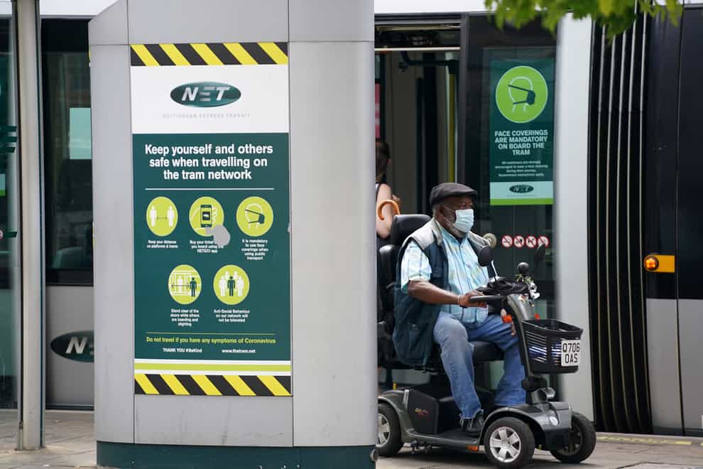 A member of the public wearing a mask and riding a mobility scooter