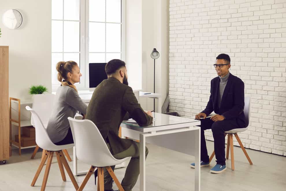 Two HR managers talking to young candidate during job interview