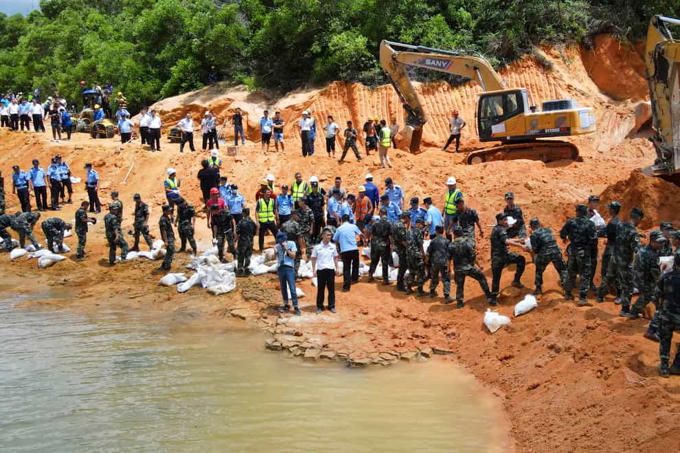 Rescuers work to build an embankment at the site of a flooded tunnel in China’s Guangdong Province