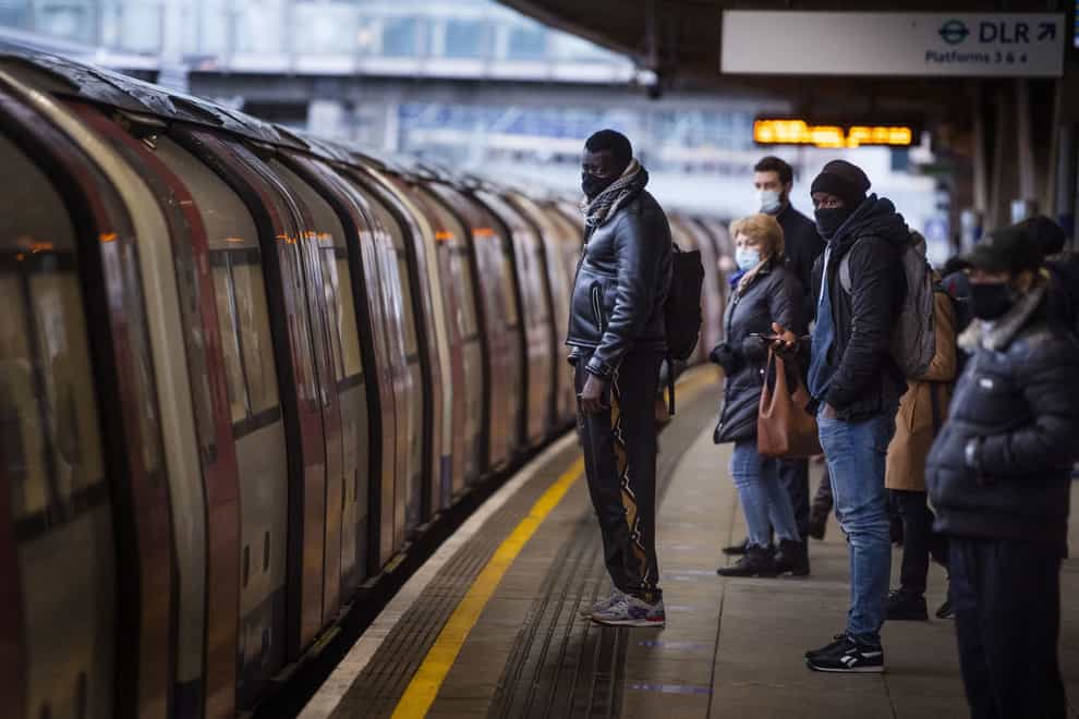 Commuters getting on a Jubilee Line Underground train at Canning Town station during the morning rush hour in London, as England’s third national lockdown to curb the spread of coronavirus continues (Victoria Jones/PA)