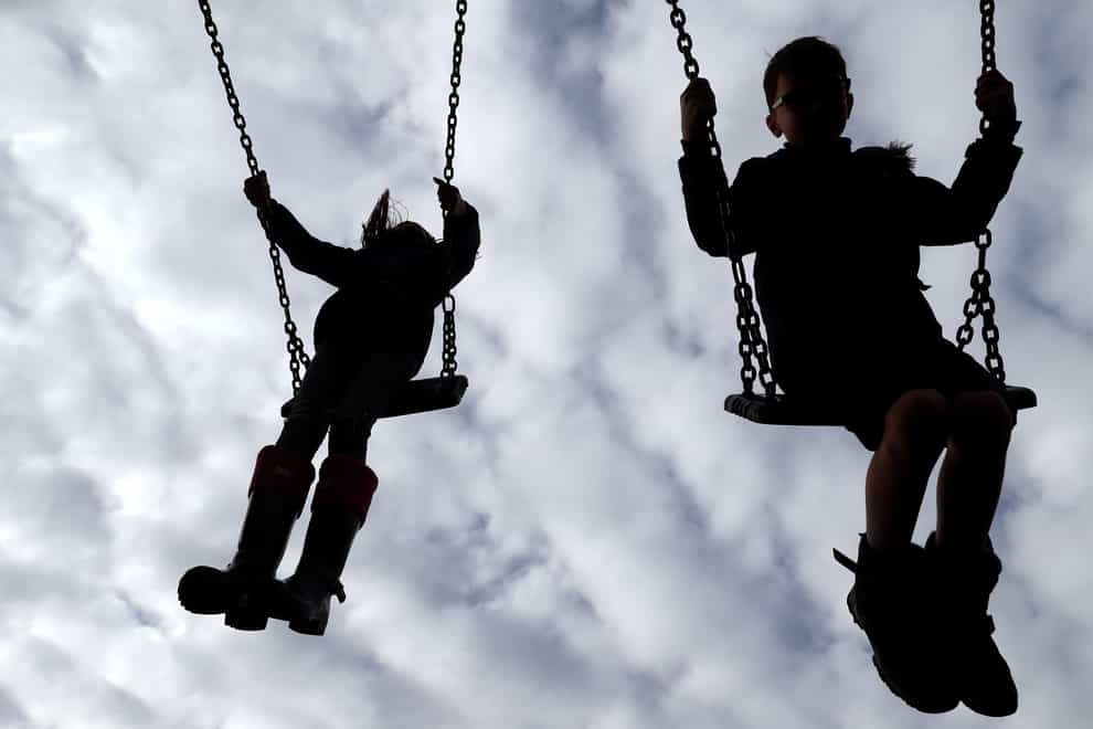 Children enjoy playing on swings in a park