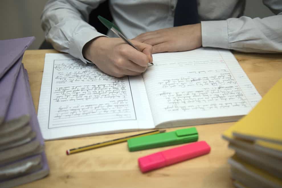 A primary school teacher marking a pupil’s English homework (PA)