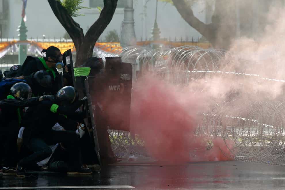 Riot police launch tear gas to protesters marching to Government House in Bangkok
