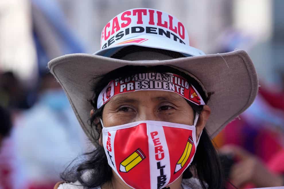 A woman in a wide-brimmed hat joins a march in support of presidential candidate Pedro Castillo