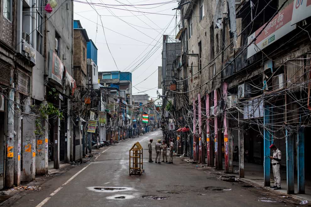 Indian Home Guard personnel stand in an empty street of Sadar Bazar wholesale market which is partially closed for violating Covid-19 guidelines (Altaf Qadri/AP)