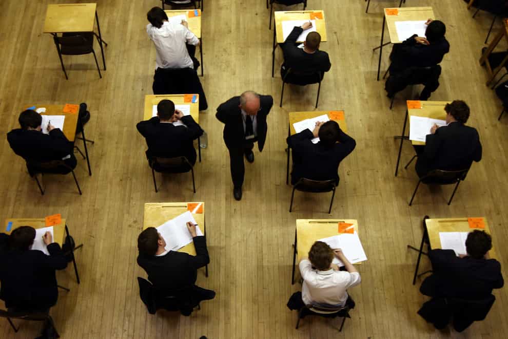 Pupils sitting at desks in an exam hall