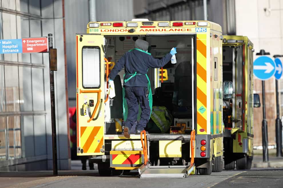 A worker in PPE cleans the back of an ambulance after dropping off a patient at the Royal London Hospital during the second wave of coronavirus in January (Yui Mok/PA)