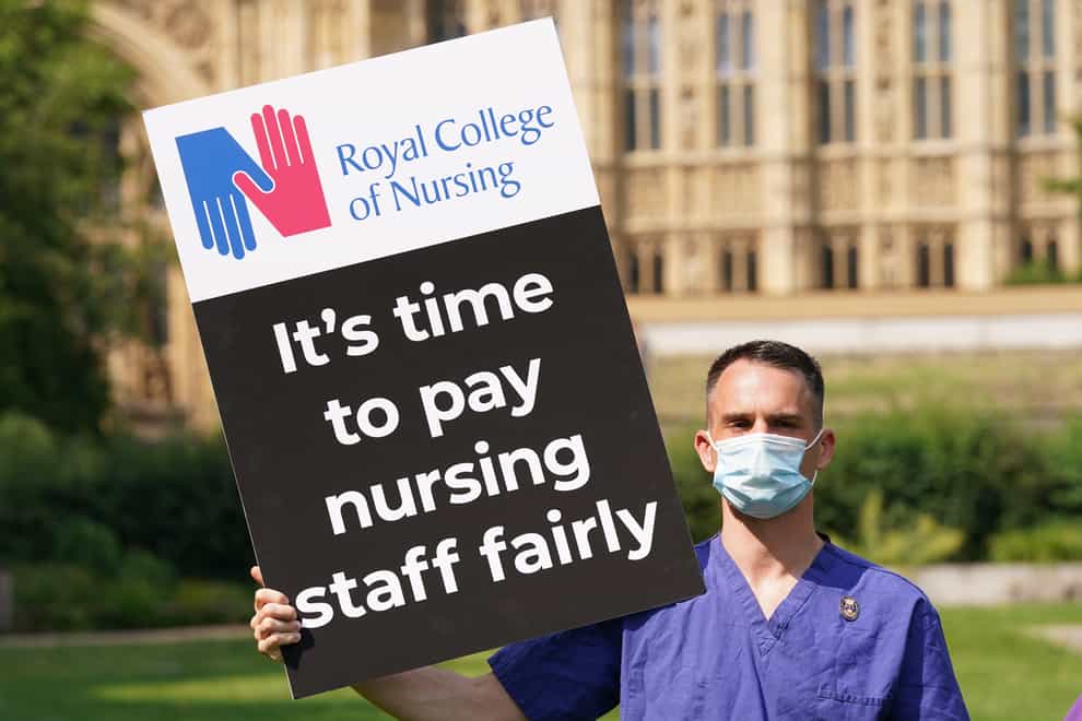 A Nurse with a placard outside the Royal College of Nursing (RCN) in Victoria Tower Gardens, London (Jonathan Brady/PA)