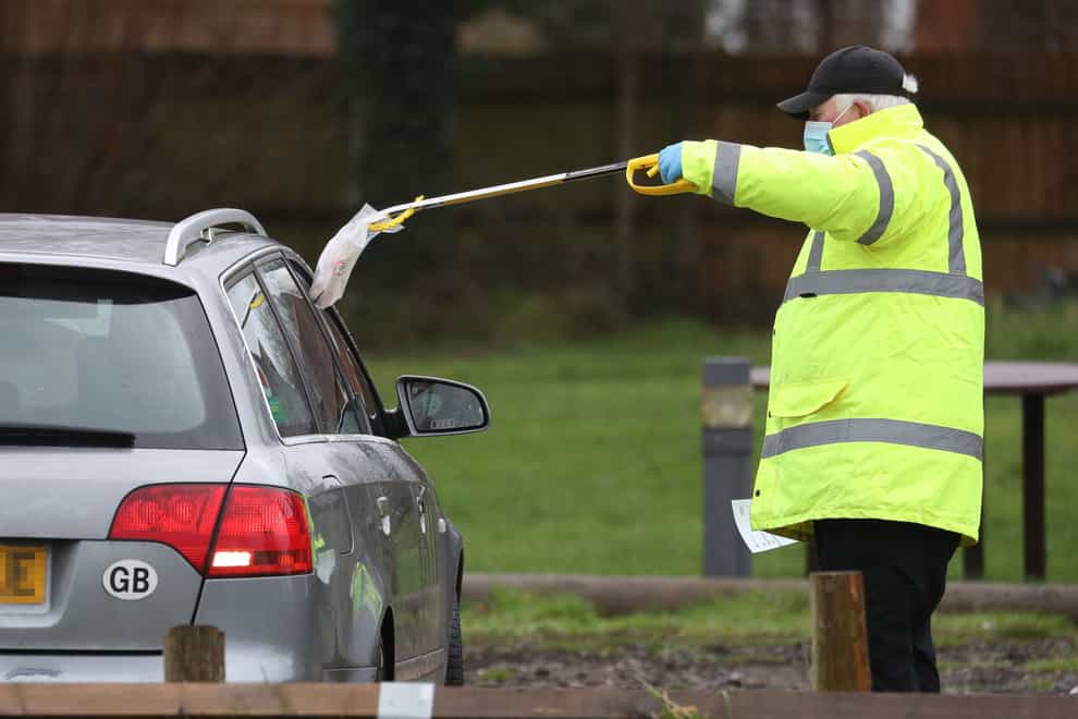 A test and trace worker in the Bramley Inn car park near Basingstoke in Hampshire, takes a coronavirus test from a driver (Andrew Matthews/PA)