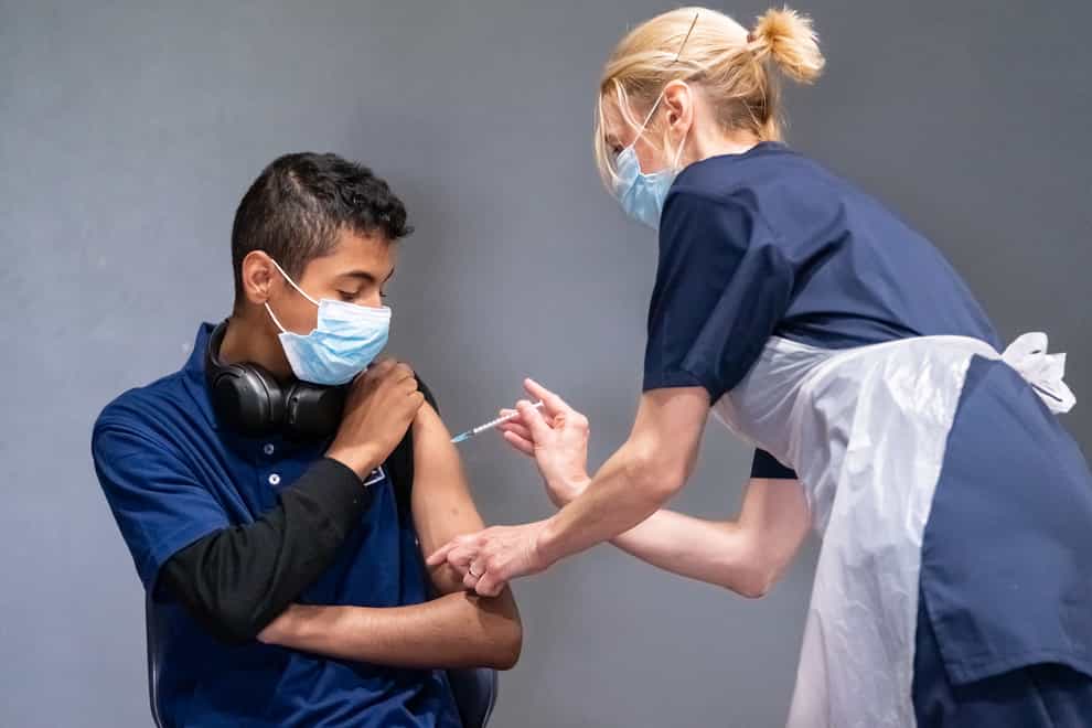 Nurse Sonia Wilson (right) vaccinates eighteen-year-old Cameron Ladd (left) with the Pfizer Covid-19 vaccine at a vaccination centre at Adwick Leisure Centre in Doncaster (Danny Lawson/PA)