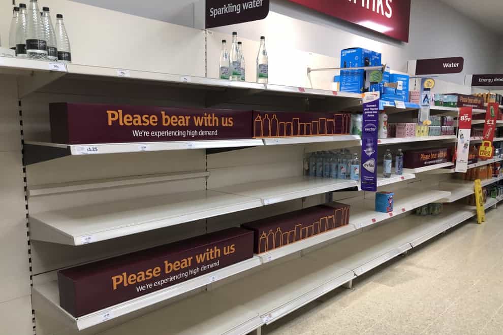 Empty shelves and signs on the soft drinks aisle of a Sainsbury’s store in Blackheath, Rowley Regis in the West Midlands. Supermarkets have urged customers not to panic buy (PA)