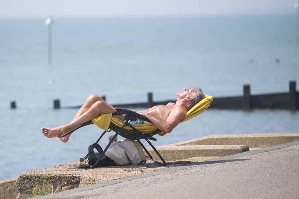 A man enjoys the sun by Southend beach in Essex (PA)