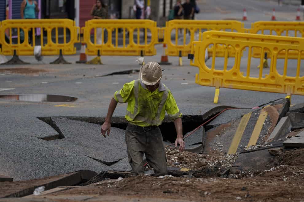 A United Utilities worker inspects the sinkhole in Green Lane, Old Swan, Liverpool (Peter Byrne/PA)
