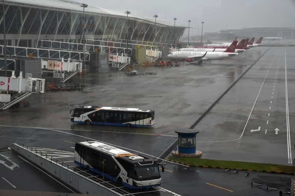 Buses and planes are parked on the tarmac after all flights were cancelled at Pudong International Airport in Shanghai, China (Andy Wong/PA)