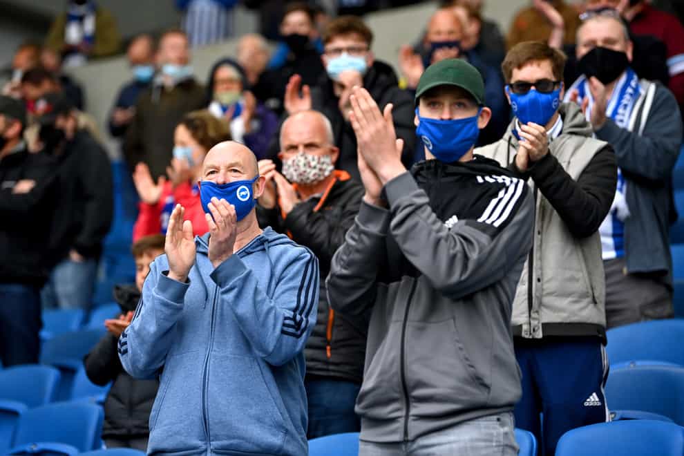Fans in masks applaud their team (PA)