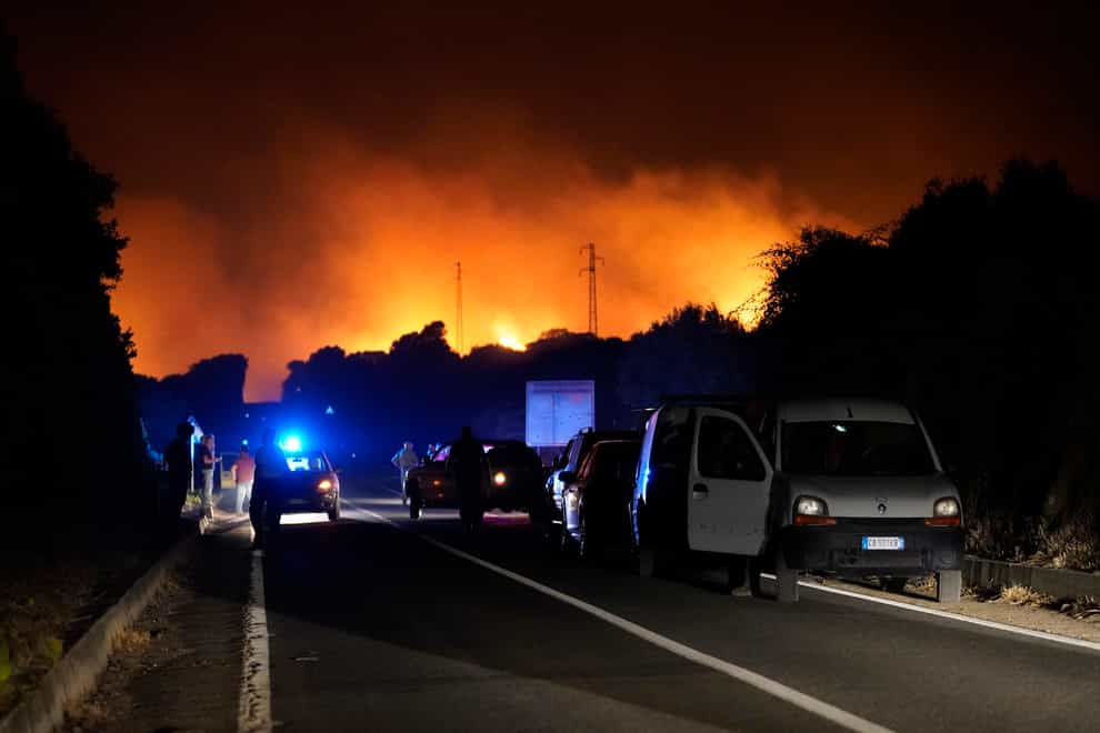 Cars are parked by the road as fires have been raging through the countryside in Cuglieri (Alessandro Tocco/LaPresse via AP)