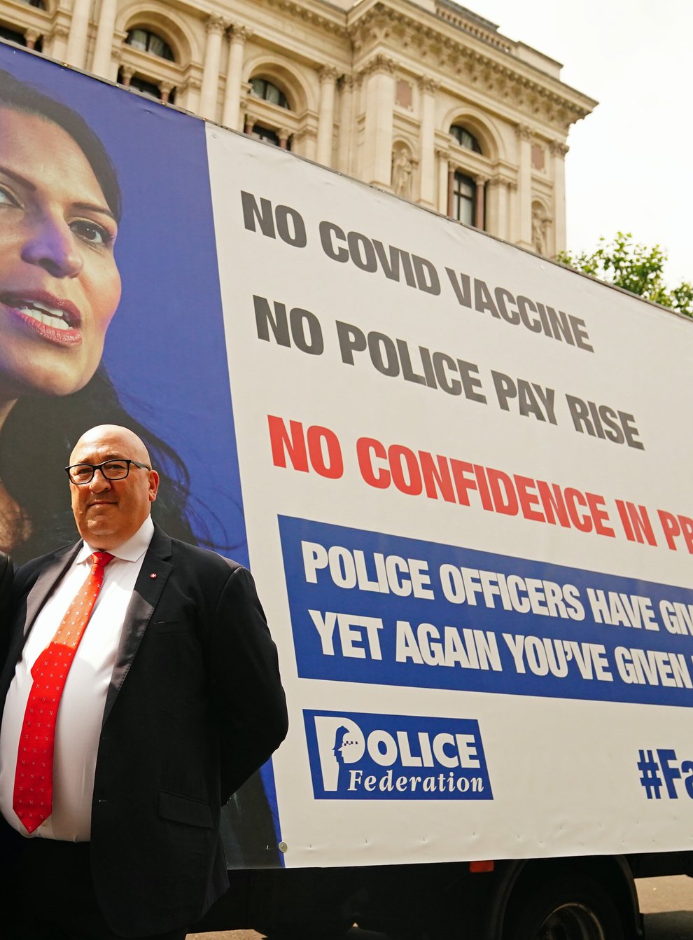 Chairman of the Police Federation John Apter (left) and Ken Marsh, Chairman of the Metropolitan Police Federation stand in front of an advertising van with a poster of Home Secretary Priti Patel as they deliver a letter to 10 Downing Street, London, setting out officers’ anger over a pay freeze and objections to the Government’s Beating Crime Plan (Victoria Jones/PA)