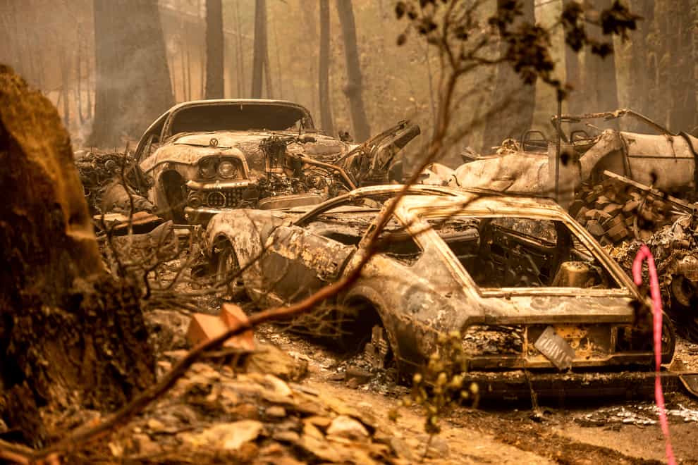Following the Dixie Fire, scorched vehicles rest in a driveway in the Indian Falls community of Plumas County, Calif., on Monday, July 26, 2021. (AP Photo/Noah Berger)