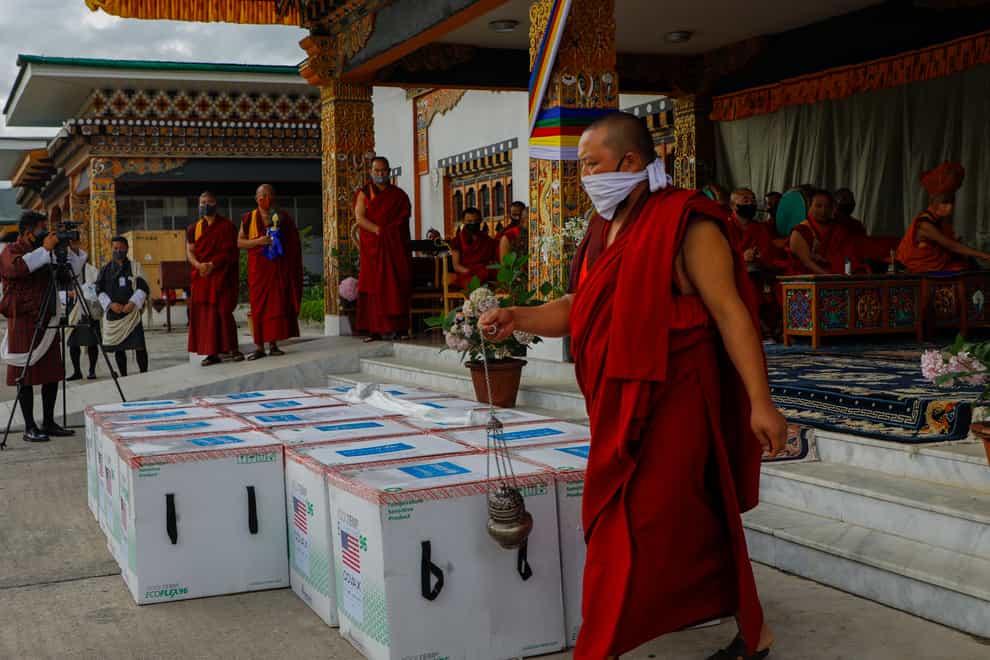 This photograph provided by UNICEF shows monks from Paro’s monastic body perform a ritual as 500,000 doses of Moderna COVID-19 vaccine gifted from the United States arrived at Paro International Airport in Bhutan (UNICEF via AP)