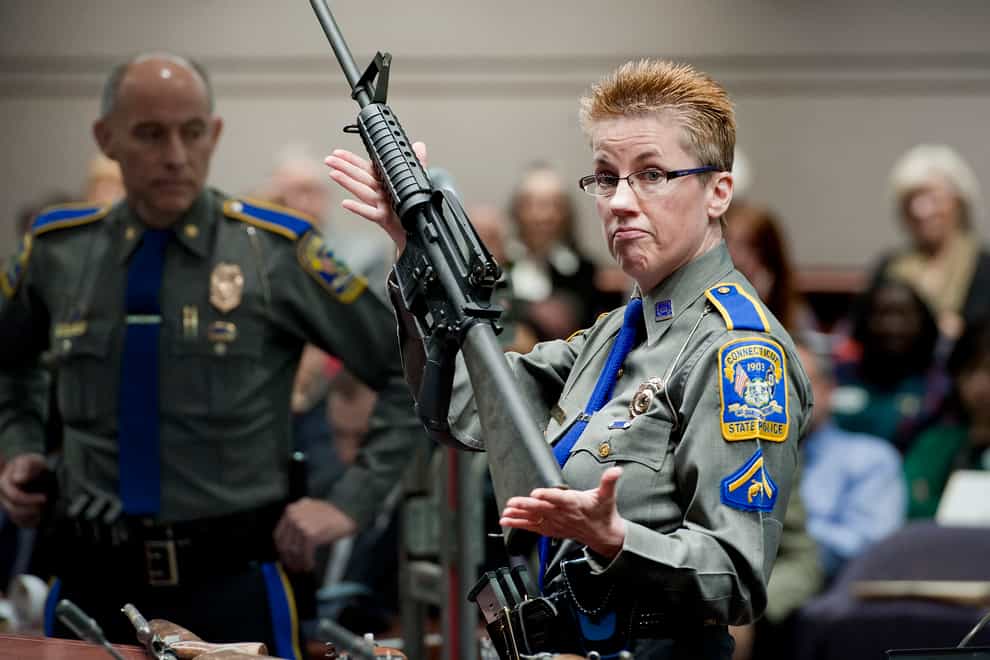 A police detective holds up a Bushmaster AR-15 rifle (Jessica Hill/AP)