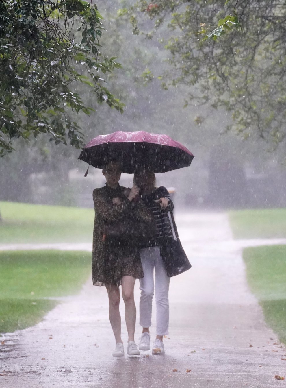 Two women walks through heavy rain in St James’s Park in central London (Victoria Jones/PA)
