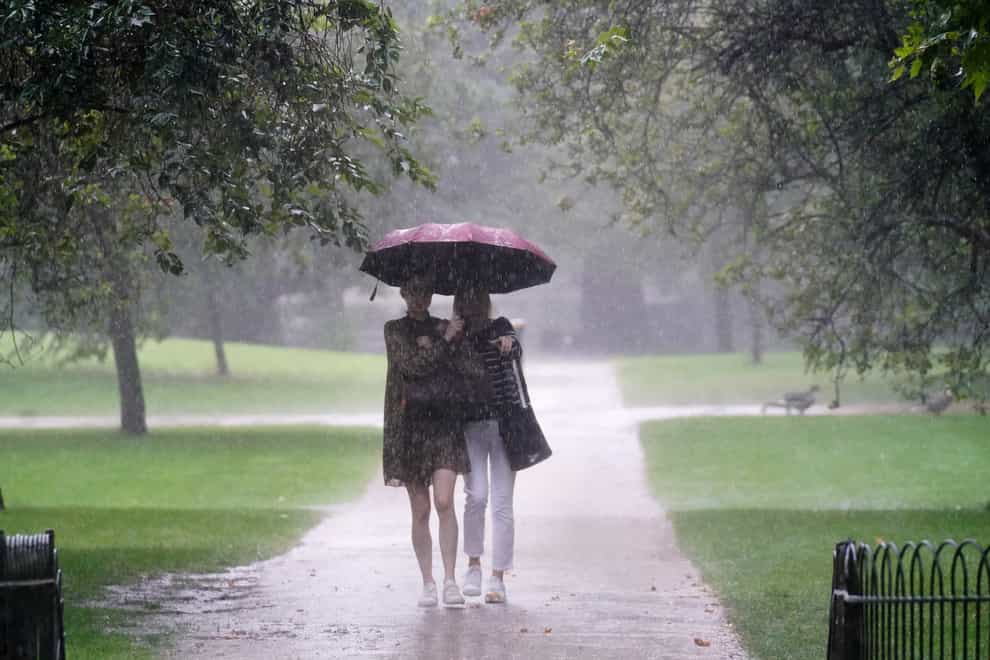 Two women walks through heavy rain in St James’s Park in central London (Victoria Jones/PA)