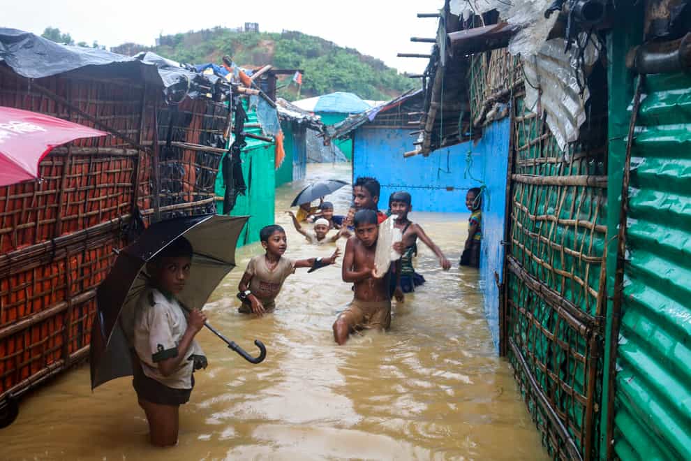 Children play in floodwaters at a Rohingya refugee camp (Shafiqur Rahman/AP)
