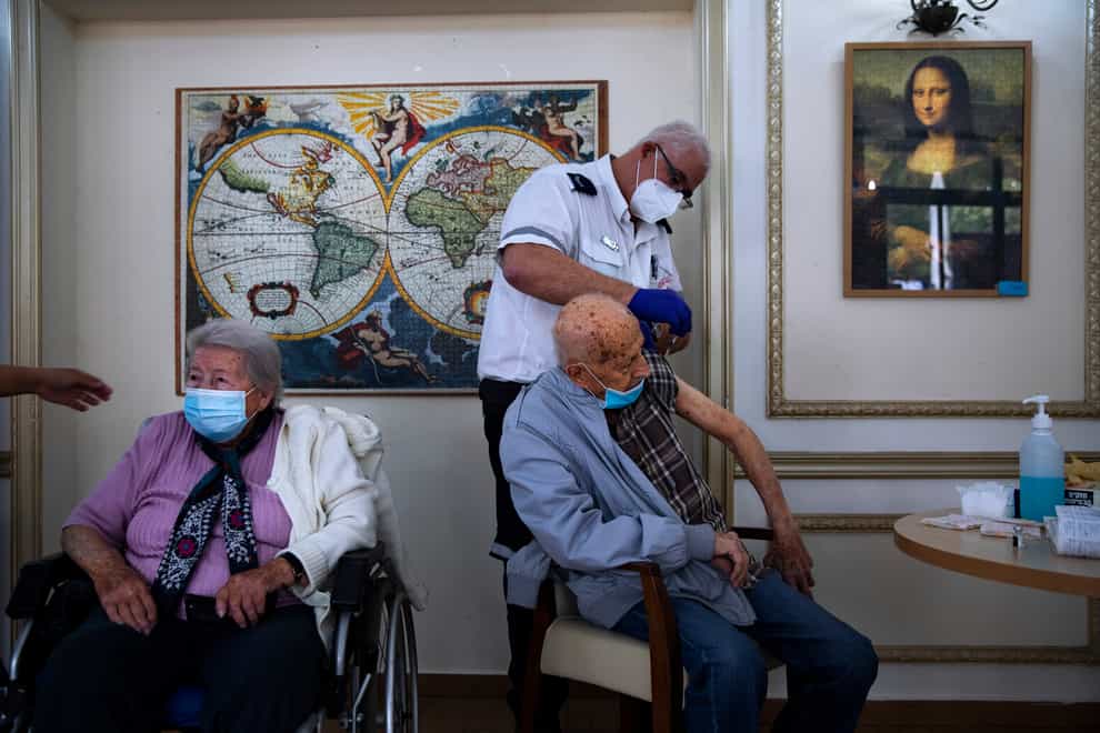 A man receives his second Pfizer-BioNTech Covid-19 vaccine from a Magen David Adom national emergency service volunteer at a private nursing home, in Ramat Gan, Israel (Oded Balilty/AP)