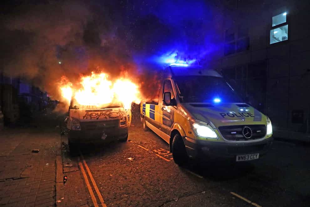 A vandalised police van on fire outside Bridewell Police Station (Andrew Matthews/PA)