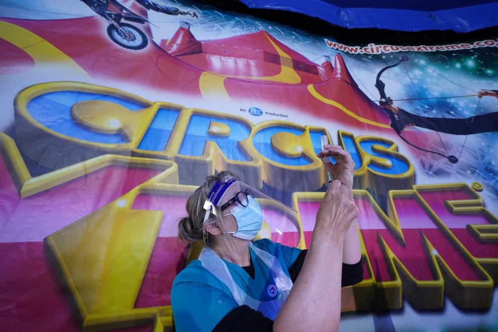 A doctor prepares a syringe at a pop-up Covid-19 vaccination clinic in the marquee of Circus Extreme in Halifax (Owen Humphreys/PA)