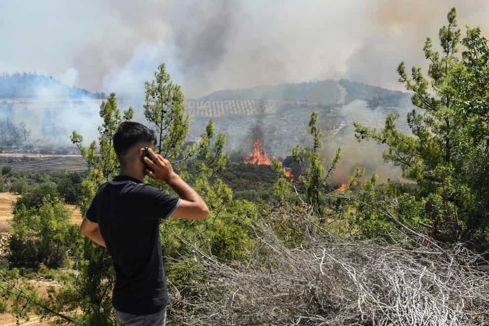 A man watches wildfires in Antalya, Turkey (AP)