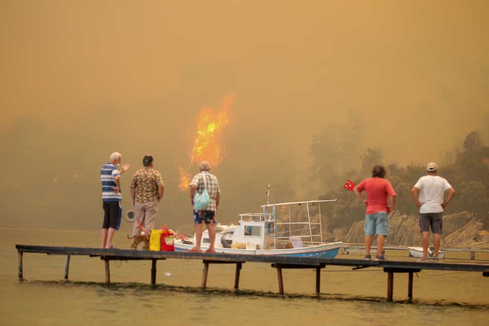 Tourists wait to be evacuated from a smoke-engulfed beach in Turkey (AP Photo/Emre Tazegul)