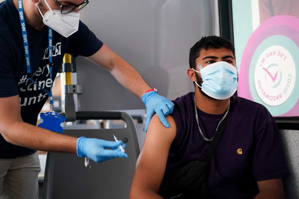 Festival goer Miles Moss receives his second Pfizer vaccine dose at a Covid-19 vaccination bus at the Latitude festival in Southwold, Suffolk (Jacob King/PA)