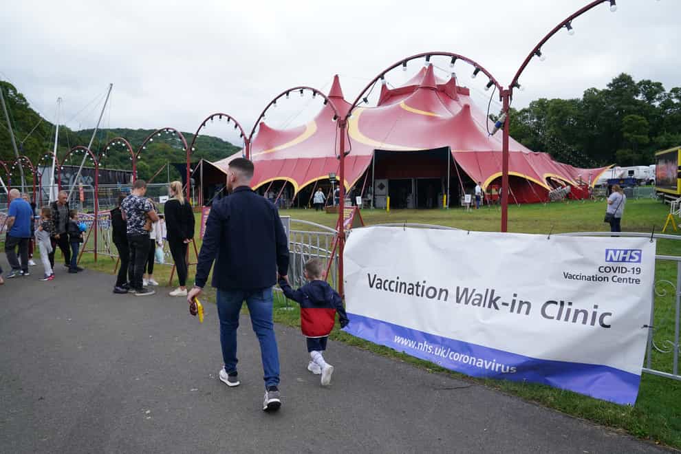 People walk past signs for the pop-up Covid-19 vaccination clinic by Circus Extreme in Halifax (Owen Humphreys/PA)