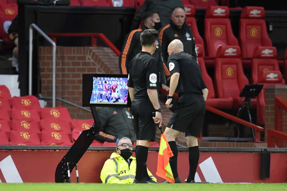 Referee Anthony Taylor consults a monitor before overturning a penalty decision in a Premier League match between Manchester United and Liverpool (Peter Powell/PA)