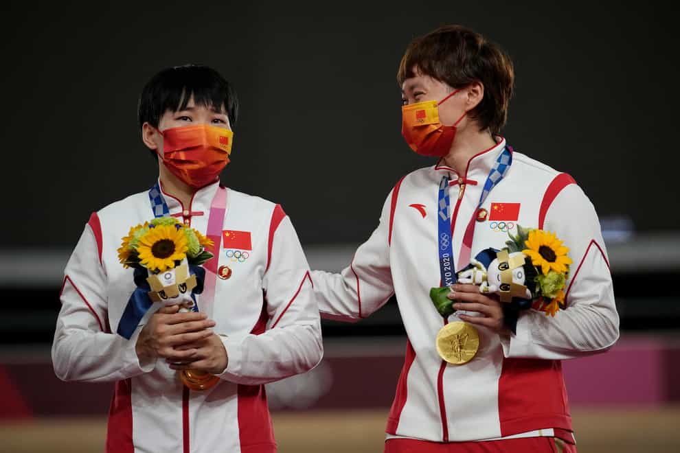 Bao Shanju, left, and Zhong Tianshi , of China, celebrate their gold medals during a ceremony for the track cycling women’s team sprint finals at the 2020 Summer Olympics (Christophe Ena/AP)