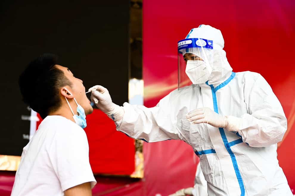 A medical worker collects a swab sample in Ruili City of southwest China’s Yunnan Province (Wang Guansen/Xinhua via AP)