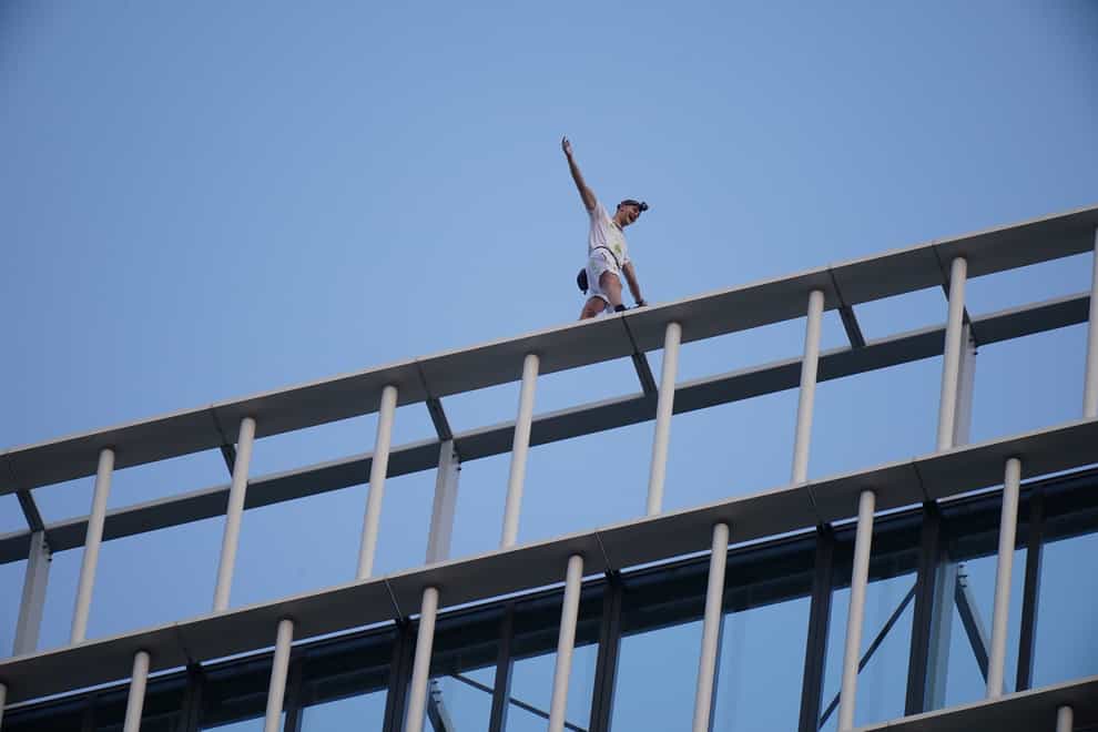 Free-solo climber George King-Thompson walks along the top of the Stratosphere Tower building, a 36-storey residential tower block in Stratford, east London (PA)