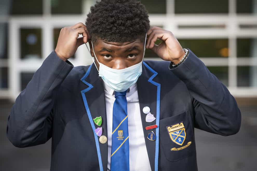 Jordy Yahve puts on his face mask before heading inside for lessons at St Andrew’s RC Secondary School in Glasgow (Jane Barlow/PA)